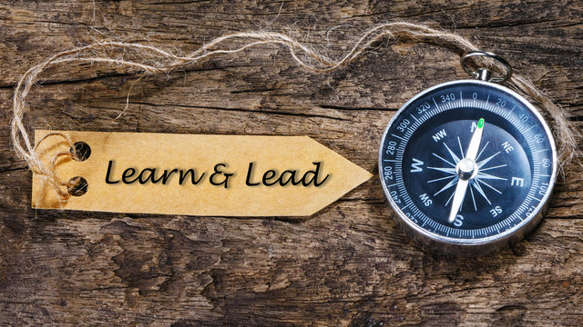 Lead & Learn - business tips handwriting on label with compass