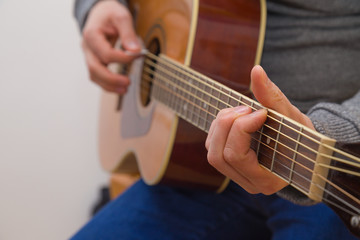 Hände eines jungen Mannes der Gitarre spielt