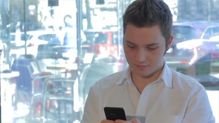 Close up of man uses cellphone at the cafe