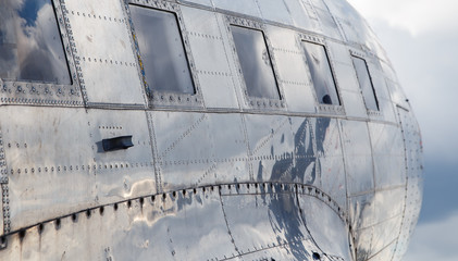 square windows of the old airplane sunny day reflection of the sky in an aluminum casing