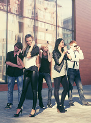 Fototapeta premium Group of young fashion men and women calling on mobile phones