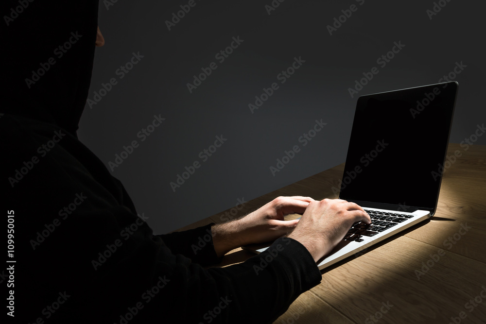 Poster man with hood hacking notebook