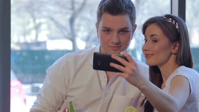Couple poses to a selfie at the cafe