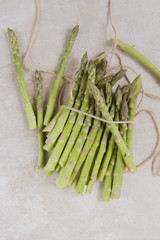 Green asparagus, gray background, white plateau. Isolated.