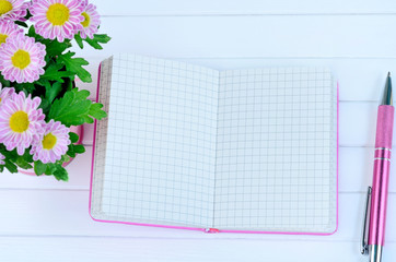 Notebook with pen and flowers