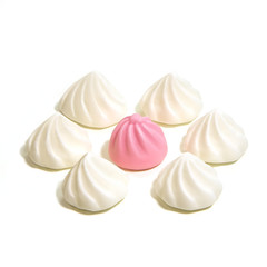 Конфеты кексы белые лежат по кругу, в центре розовый на белом фоне.  