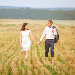 couple walking on field.