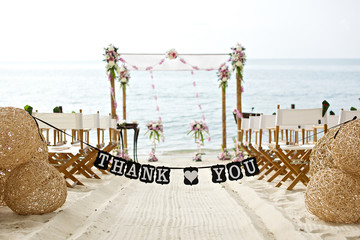 thank you words banner at beautiful beach wedding set up chairs