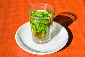 Traditional moroccan mint tea in glass on th table.  Close up photo.