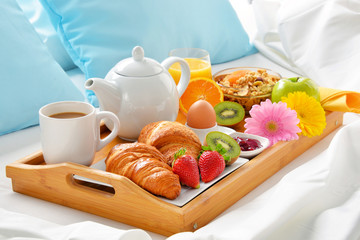 Breakfast tray in bed in hotel room