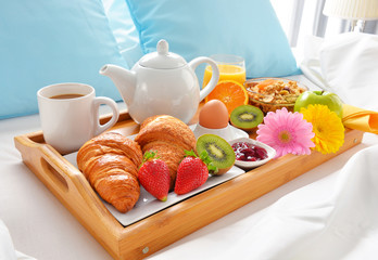 Breakfast tray in bed in hotel room