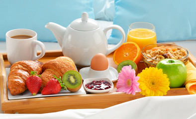Breakfast tray in bed in hotel room