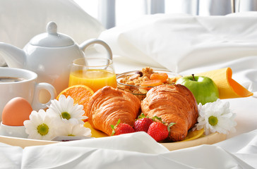 Breakfast tray in bed in hotel room