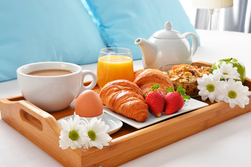 Breakfast tray in bed in hotel room