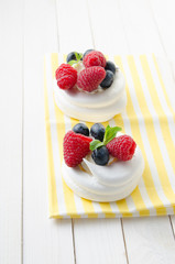 Homemade pavlova meringue cake with fresh berries and whipped cream. Morning. Dessert.