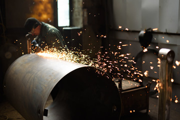 Welding machine close up and industrial worker on the plant