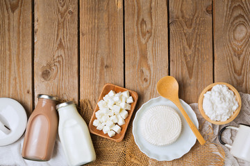 Milk bottles and cheese on wooden rustic background. View from above. Flat lay