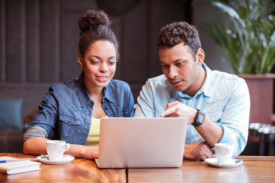 Cute young guy and girl using notebook