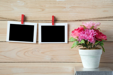 empty photo frames hanging with clothespins on wooden background