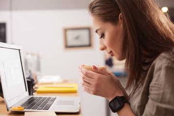 Cute lady is enjoying hot drink