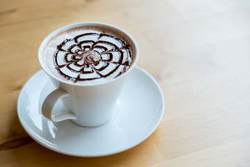 hot chocolate latte in white cup on wooden table