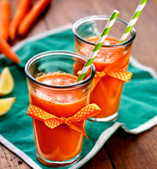 Fresh carrot juice in glasses on a wooden table