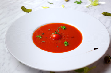 Tomato soup in a bowl on a marble 