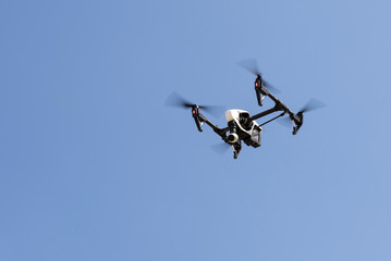 Drone hovering in a bright blue sky
