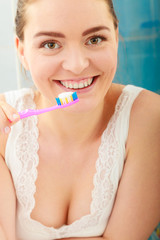 woman brushing cleaning teeth. Girl with toothbrush in bathroom.