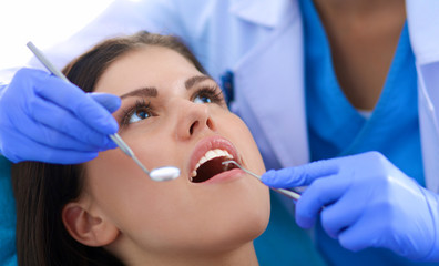 Woman dentist working at her patients teeth