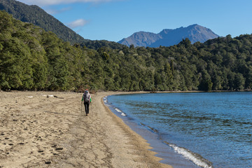 Woman hiker walking along shore of Lake Te Anau