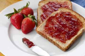 slice of bread with strawberry fruit and jam