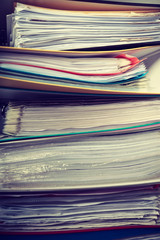 Piles of binders with documents.