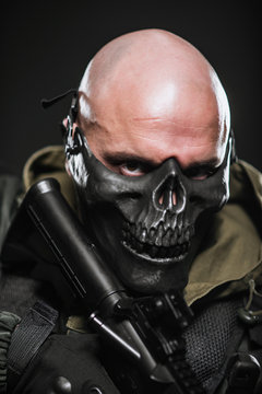  soldier military man in a black mask on a dark background.