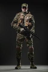 Soldier man hold Machine gun on a  dark background