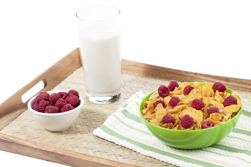 bowl of cereal and raspberries with glass of  milk , bowl of raspberries on tray