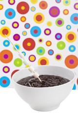 marshmallow in stick on bowl of melted chocolate