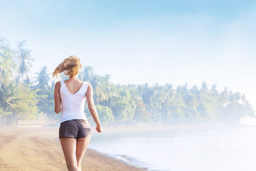 Fototapeta na wymiar Young woman jogging on the beach