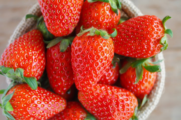strawberries in small sack on wooden table background