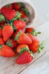 strawberries in small sack on wooden table background