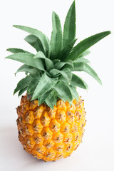 Ripe Pineapple with green leaves on white background