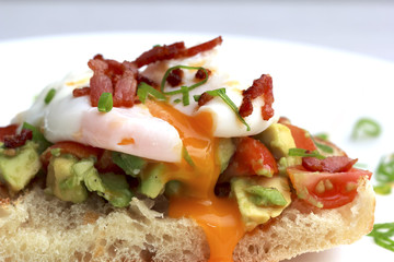 Poached eggs bacon tomatoes and avocado on toast
