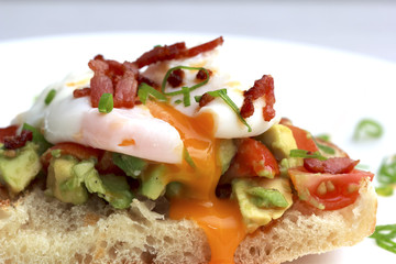 Poached eggs bacon tomatoes and avocado on toast