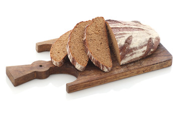 loaf and slices of rye bread on a cutting boards isolate
