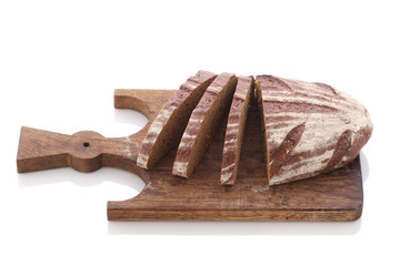 loaf and slices of rye bread on a cutting boards isolate