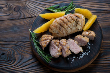 Whole and sliced roasted duck breast fillet with orange