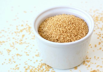 Wholegrain couscous in the bowl on the white background