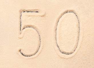 50 number written on beach sand