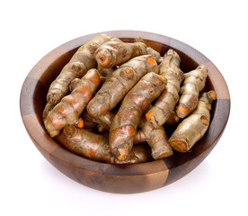 Turmeric roots in wooden bowl on white background