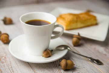 Cup of coffee, sweet buns and acorns
